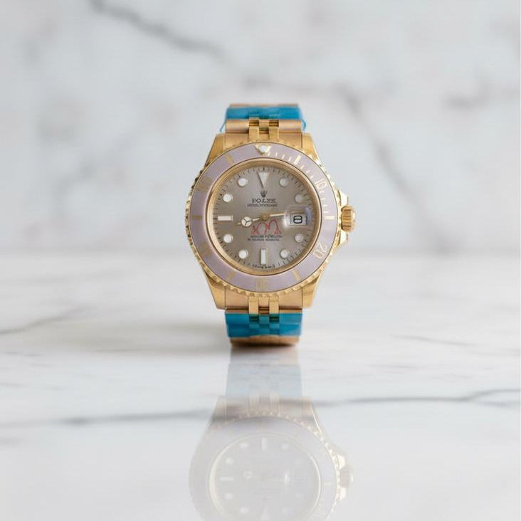 Gold watch with blue accents on a white surface